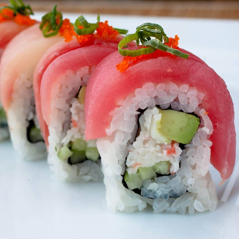 Four Sansai Japanese Grill sushi rolls with tuna, avocado, and roe on a white plate.