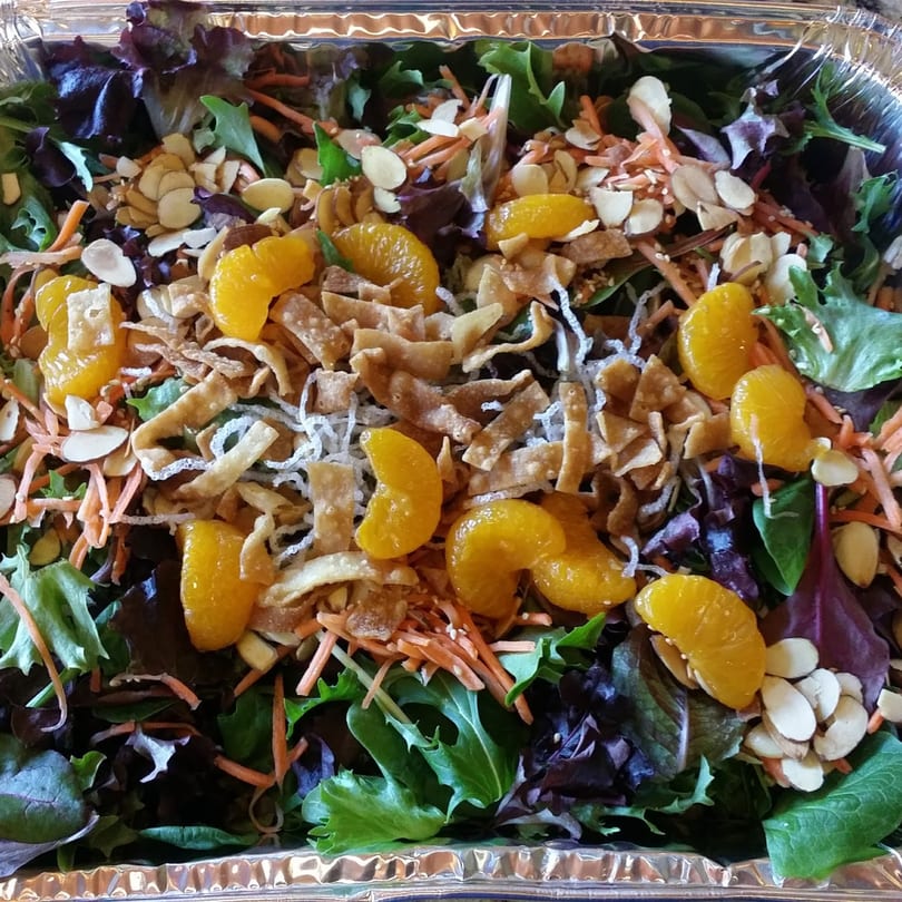 A vibrant Sansai Japanese Grill salad with mixed greens, mandarin oranges, almonds, and crispy wonton strips.